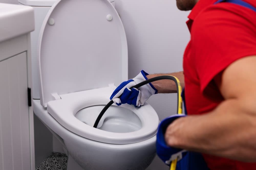 Drainage engineer unblocking a blocked toilet
