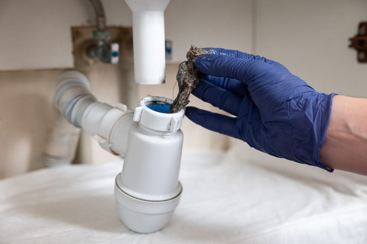 Drainage Engineer showing a blockage in the pipes under the sink.