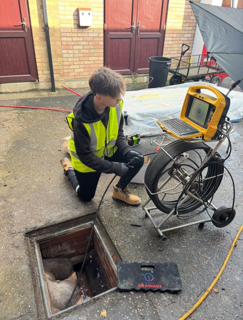 Drainage engineer inspecting an external drain after completing a no dig patch liner repair on a damaged pipe